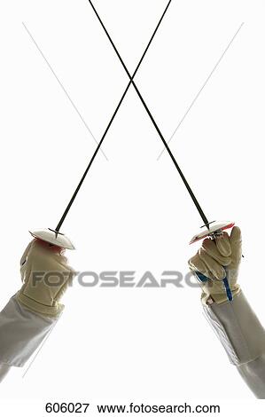 Two human hands holding fencing foils in confrontation View Large Photo Image Stock Photo - Two human hands holding fencing foils in confrontation. Fotosearch