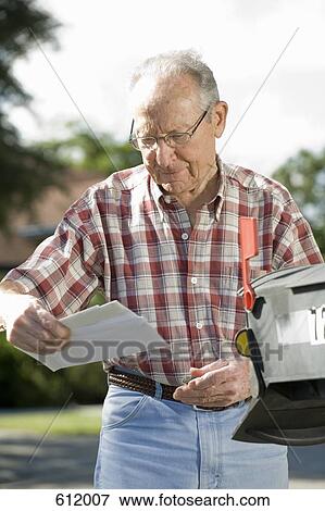 Stock Photo - A senior man checking the mailbox. Fotosearch