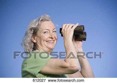 Stock Photo - A senior woman using binoculars. Fotosearch