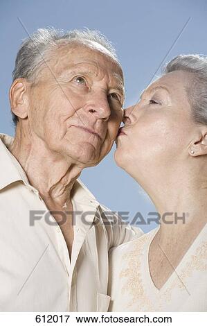 Stock Photo - A woman kissing a man's cheek. Fotosearch