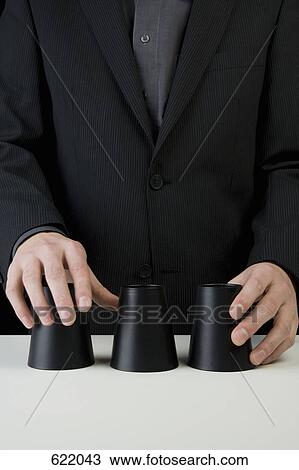 A businessman playing the shell game View Large Photo Image Stock Image - A businessman playing the shell game. Fotosearch