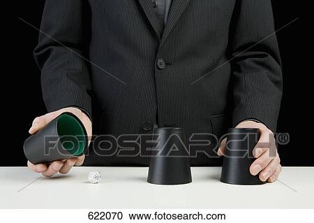 A businessman playing the shell game View Large Photo Image Stock Image - A businessman playing the shell game. Fotosearch