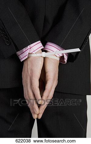 A businessman with his hands tied behind his back View Large Photo Image Stock Photo - A businessman with his hands tied behind his back. Fotosearch