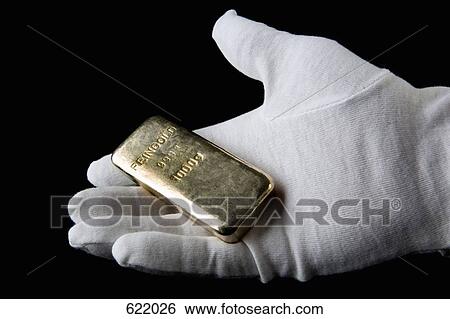 A gloved hand holding a gold bar View Large Photo Image Stock Photograph - A gloved hand holding a gold bar. Fotosearch