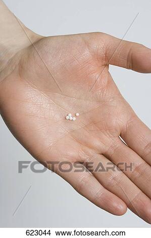 A hand holding homeopathic medicine View Large Photo Image Picture - A hand holding homeopathic medicine. Fotosearch