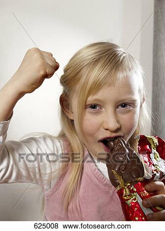 A girl eating a chocolate Santa Claus View Large Photo Image Stock Photo - A girl eating a chocolate Santa Claus. Fotosearch
