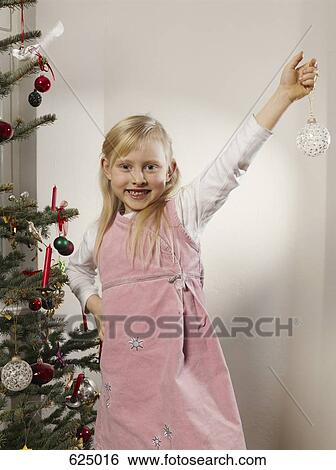 A girl holding a Christmas bauble View Large Photo Image Stock Photograph - A girl holding a Christmas bauble. Fotosearch