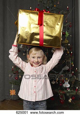 A girl holding a Christmas present View Large Photo Image Stock Image - A girl holding a Christmas present. Fotosearch