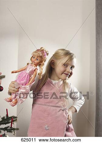 Stock Image - A girl holding a doll. Fotosearch
