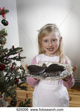 A girl holding a plate of cookies at Christmas View Large Photo Image Stock Photograph - A girl holding a plate of cookies at Christmas. Fotosearch