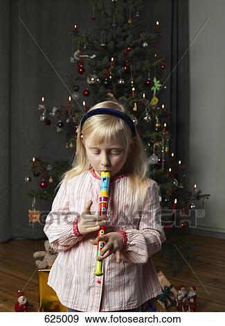 A girl playing a recorder in front of a Christmas tree View Large Photo Image Stock Photo - A girl playing a recorder in front of a Christmas tree. Fotosearch
