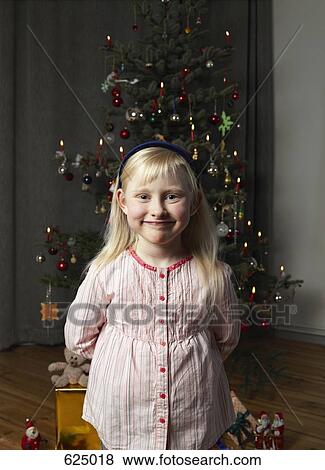 Portrait of a girl in front of a Christmas tree View Large Photo Image Stock Photo - Portrait of a girl in front of a Christmas tree. Fotosearch
