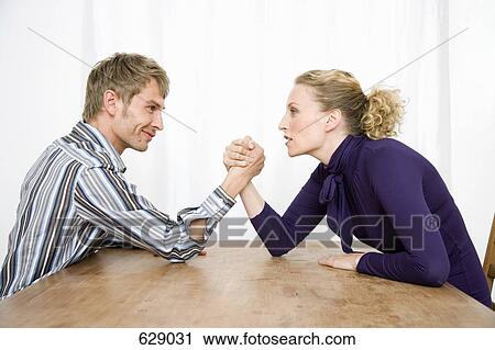 Stock Image - A couple arm wrestling. Fotosearch