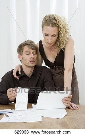 A couple looking at bills View Large Photo Image Stock Image - A couple looking at bills. Fotosearch