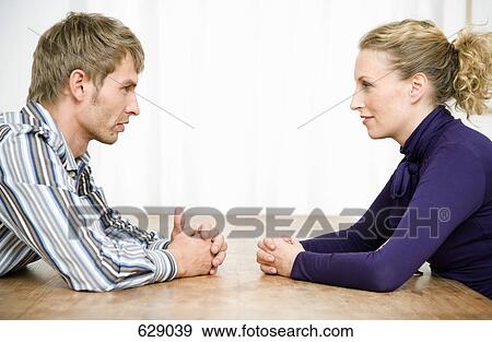 A couple staring at each other across a table View Large Photo Image Stock Photo - A couple staring at each other across a table. Fotosearch