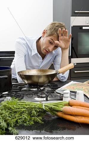A man leaning over a pan and looking frustrated View Large Photo Image Stock Image - A man leaning over a pan and looking frustrated. Fotosearch