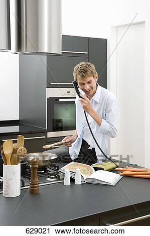 A man sitting on a kitchen worktop and using the telephone View Large Photo Image Stock Image - A man sitting on a kitchen worktop and using the telephone. Fotosearch
