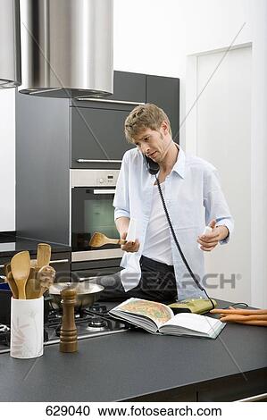 A man sitting on a kitchen worktop and using the telephone View Large Photo Image Stock Image - A man sitting on a kitchen worktop and using the telephone. Fotosearch
