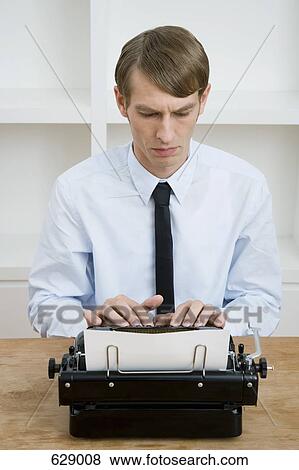 Stock Photo - A man using a typewriter. Fotosearch