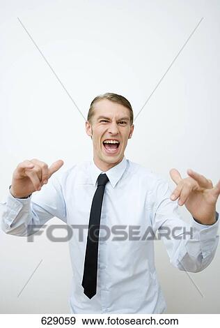 A mid adult man raising his arms in a confrontational gesture View Large Photo Image Stock Photo - A mid adult man raising his arms in a confrontational gesture. Fotosearch