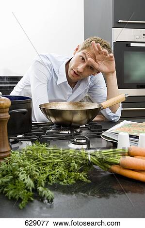 A mid adult man wiping his brow while cooking View Large Photo Image Stock Photo - A mid adult man wiping his brow while cooking. Fotosearch