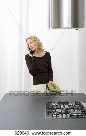 A mid adult woman on a landline phone View Large Photo Image Stock Photograph - A mid adult woman on a landline phone. Fotosearch