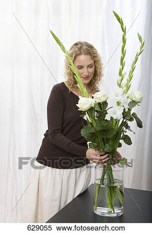 A woman arranging a bouquet of sword lilies and roses View Large Photo Image Stock Photography - A woman arranging a bouquet of sword lilies and roses. Fotosearch