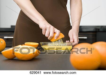 A woman juicing oranges View Large Photo Image Stock Image - A woman juicing oranges. Fotosearch