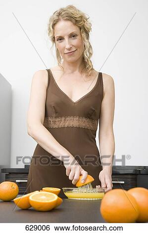 A woman juicing oranges View Large Photo Image Stock Photograph - A woman juicing oranges. Fotosearch