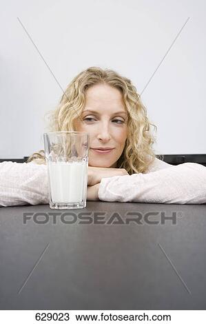 A woman looking at a glass of milk View Large Photo Image Stock Image - A woman looking at a glass of milk. Fotosearch