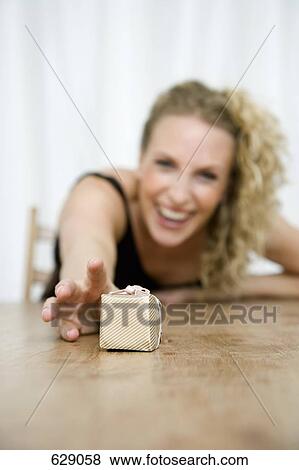 A woman reaching to for a wrapped gift View Large Photo Image Stock Photo - A woman reaching to for a wrapped gift. Fotosearch