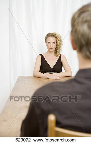 A woman sitting across the table from a man View Large Photo Image Stock Image - A woman sitting across the table from a man. Fotosearch