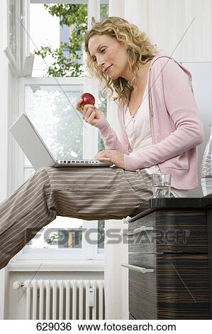 A woman using her laptop View Large Photo Image Stock Photograph - A woman using her laptop. Fotosearch