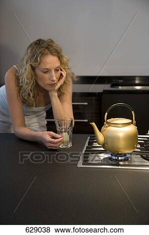 A woman waiting for a kettle to boil View Large Photo Image Stock Photo - A woman waiting for a kettle to boil. Fotosearch
