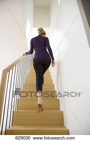 A woman walking upstairs View Large Photo Image Stock Image - A woman walking upstairs. Fotosearch