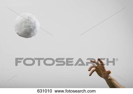 Stock Image - A human hand throwing a large cotton ball. Fotosearch