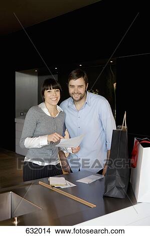 Picture - A man and a woman reading a document. Fotosearch