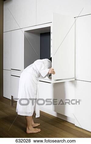 A man looking into an opened cabinet View Large Photo Image Stock Photo - A man looking into an opened cabinet. Fotosearch