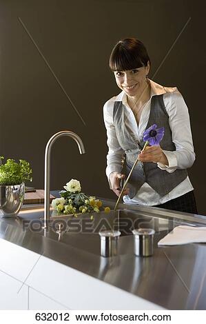 Stock Image - A woman pruning cut flowers. Fotosearch