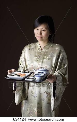 A woman in a kimono carrying a tray of sushi and tea View Large Photo Image Picture - A woman in a kimono carrying a tray of sushi and tea. Fotosearch