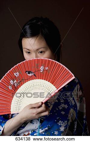 A woman in a kimono holding a folding fan View Large Photo Image Stock Photo - A woman in a kimono holding a folding fan. Fotosearch