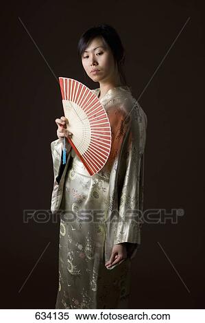 A woman in a kimono holding a folding fan View Large Photo Image Stock Photography - A woman in a kimono holding a folding fan. Fotosearch