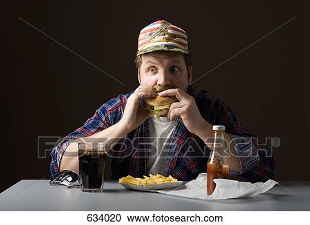 Stereotypical American man eating a burger View Large Photo Image Stock Image - Stereotypical American man eating a burger. Fotosearch