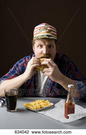 Stereotypical American man eating a burger View Large Photo Image Stock Image - Stereotypical American man eating a burger. Fotosearch