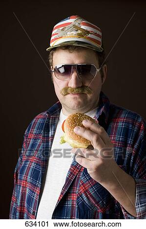 Stereotypical American man holding a hamburger View Large Photo Image Stock Image - Stereotypical American man holding a hamburger. Fotosearch