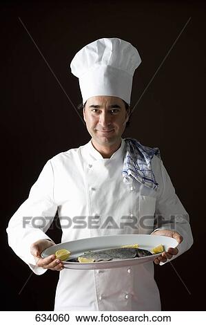 Stereotypical chef posing with a platter of fish View Large Photo Image Stock Image - Stereotypical chef posing with a platter of fish. Fotosearch