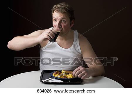 Stereotypical Englishman eating English breakfast and drinking a pint View Large Photo Image Stock Photograph - Stereotypical Englishman eating English breakfast and drinking a pint. Fotosearch