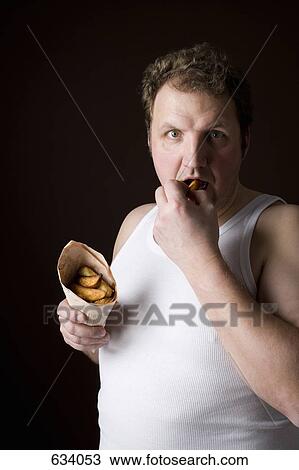 Stereotypical Englishman eating fish and chips in wrapped newspaper View Large Photo Image Stock Image - Stereotypical Englishman eating fish and chips in wrapped newspaper. Fotosearch
