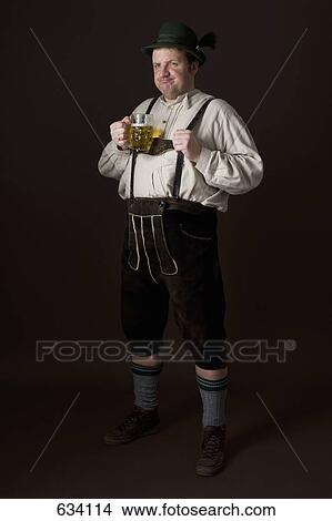 Stereotypical German man in Bavarian costume holding a beer View Large Photo Image Picture - Stereotypical German man in Bavarian costume holding a beer. Fotosearch