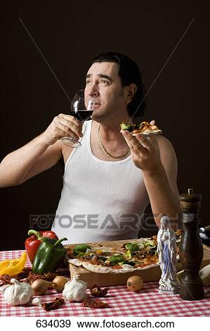 Stock Photo - Stereotypical Italian man holding a wine glass and eating pizza. Fotosearch